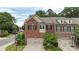 Daytime shot of a brick townhome featuring a two-car garage, landscaping, and street signage at 5422 Shannon Bell Ln, Charlotte, NC 28277