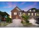 Stunning evening view of a brick townhome with a two-car garage and well-maintained landscaping at 5422 Shannon Bell Ln, Charlotte, NC 28277