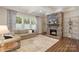 Comfortable living room with stone fireplace, trey ceiling, large windows, and hardwood floors at 5422 Shannon Bell Ln, Charlotte, NC 28277