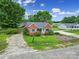 Quaint brick home with mature landscaping, a gray roof, and light blue shutters surrounded by lush green grass and trees at 5573 Main St, Fort Lawn, SC 29714