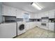 Bright kitchen featuring white cabinets, tile floors, and laundry machines at 5573 Main St, Fort Lawn, SC 29714