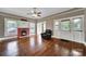 Inviting living room featuring hardwood floors, a brick fireplace, and an abundance of natural light with a cozy chair at 5573 Main St, Fort Lawn, SC 29714