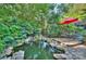 Tranquil backyard pond featuring a waterfall, lush greenery, and a seating area at 6005 Bryant Ln, Waxhaw, NC 28173
