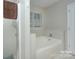 Clean and modern bathroom featuring a soaking tub with shower, and neutral tile at 6005 Bryant Ln, Waxhaw, NC 28173