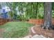 Spacious backyard with lush green grass, mature trees, and a charming brick paver walkway at 624 Oakland Ave, Charlotte, NC 28204
