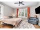 Bright bedroom features hardwood floors, ceiling fan, large windows and comfortable chair at 624 Oakland Ave, Charlotte, NC 28204