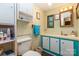 Compact bathroom featuring colorful cabinets, a mirror, and floral wallpaper at 6804 Lineberger Rd, Denver, NC 28037