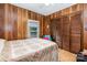 Cozy bedroom with wood paneled walls, closet, and patterned bedspread at 6804 Lineberger Rd, Denver, NC 28037