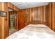 Bedroom featuring wood paneled walls, a bed, and closet with an open door at 6804 Lineberger Rd, Denver, NC 28037