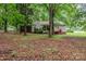 View of rear exterior elevation featuring a screened-in porch, red stairs, and mature trees at 6804 Lineberger Rd, Denver, NC 28037