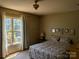 Cozy bedroom with natural light, features a floral-patterned bedspread, ceiling fan and hardwood flooring at 711 4Th Sw Ave # B3, Conover, NC 28613