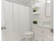 Cozy bathroom featuring a shower with a curtain, floating shelves, and marble-top vanity at 716 Ellsworth Rd, Charlotte, NC 28211