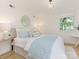 Serene bedroom with a plush bed, soft blue accents, and natural light from a window at 716 Ellsworth Rd, Charlotte, NC 28211