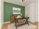 Home office features a bold green accent wall, stylish desk, and ample storage with natural light at 716 Ellsworth Rd, Charlotte, NC 28211