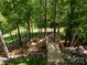Wooden steps provide access through a wooded area from the home to the backyard at 7730 Windsor Forest Pl, Harrisburg, NC 28075