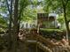Back of the property showing wooden steps to the home with a screened in back porch with bar and patio set at 7730 Windsor Forest Pl, Harrisburg, NC 28075
