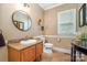 Well-lit bathroom with granite countertop vanity and decorative circular mirror at 7730 Windsor Forest Pl, Harrisburg, NC 28075