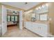 Bathroom featuring double vanity and a door leading to the bedroom at 7730 Windsor Forest Pl, Harrisburg, NC 28075