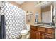 Well-maintained bathroom featuring a patterned shower curtain, toilet, vanity, and neutral-colored walls at 7730 Windsor Forest Pl, Harrisburg, NC 28075