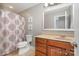 Bathroom showcasing a vanity, mirror, and a shower with a decorative curtain, providing a functional space at 7730 Windsor Forest Pl, Harrisburg, NC 28075