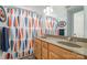 Bright bathroom featuring a double sink vanity and a patterned shower curtain, combining style and functionality at 7730 Windsor Forest Pl, Harrisburg, NC 28075