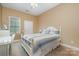 Bright bedroom featuring a white bed frame, desk, and natural light from the window at 7730 Windsor Forest Pl, Harrisburg, NC 28075