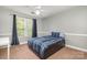 Bedroom features carpet, a ceiling fan, a window, and a cozy bed with stylish bedding for a comfortable retreat at 7730 Windsor Forest Pl, Harrisburg, NC 28075