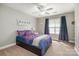 Cozy bedroom featuring a ceiling fan, plush carpet, and a comfortable bed with stylish patterned bedding at 7730 Windsor Forest Pl, Harrisburg, NC 28075