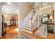 Inviting foyer featuring a staircase with hardwood steps, elegant wainscoting, and access to multiple rooms with hardwood floors at 7730 Windsor Forest Pl, Harrisburg, NC 28075