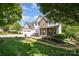 Beautiful two-story home with a well-manicured lawn, stone accents, and a cozy front porch at 7730 Windsor Forest Pl, Harrisburg, NC 28075