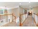 Spacious hallway with wood railing, neutral walls, and access to other rooms within the home at 7730 Windsor Forest Pl, Harrisburg, NC 28075