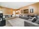 Spacious living area with a gray sectional sofa, modern decor, and hardwood floors, ideal for relaxation and entertainment at 7730 Windsor Forest Pl, Harrisburg, NC 28075
