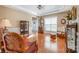 Elegant living room featuring hardwood floors, a decorative curio cabinet, and a comfortable rocking chair at 7730 Windsor Forest Pl, Harrisburg, NC 28075
