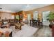 Open-concept living room boasting hardwood floors, a leather sofa, and a dining table, perfect for modern living at 7730 Windsor Forest Pl, Harrisburg, NC 28075