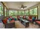 Screened porch with comfortable seating, offering a relaxing outdoor space surrounded by lush greenery at 7730 Windsor Forest Pl, Harrisburg, NC 28075