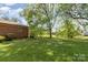 Expansive backyard with lush lawn and mature trees, ideal for outdoor activities and relaxation at 812 Clinton Ave, Lancaster, SC 29720