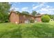 Lush backyard with a brick house and landscaping, perfect for enjoying nature and outdoor living at 812 Clinton Ave, Lancaster, SC 29720