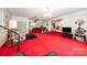 Recreational basement featuring a wet bar, an exercise bike, a tv, and a red carpet flooring at 812 Clinton Ave, Lancaster, SC 29720