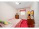 Bedroom featuring pink walls, a floral quilt, and warm lighting, radiating a cozy atmosphere at 812 Clinton Ave, Lancaster, SC 29720