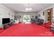 Expansive living room with red carpet, unique lighting, and large windows at 812 Clinton Ave, Lancaster, SC 29720