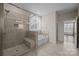 Luxurious bathroom featuring a tiled shower, soaking tub, and elegant fixtures creating a spa-like experience at 8614 Goodman Park Ct, Charlotte, NC 28277