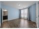 Bedroom with hardwood floors and large window with custom curtains at 8614 Goodman Park Ct, Charlotte, NC 28277