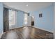 Light filled bedroom featuring wood floors, soft blue walls, and access to an ensuite bathroom at 8614 Goodman Park Ct, Charlotte, NC 28277