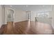 Expansive living room featuring hardwood floors, arched doorways, and a staircase with natural light, bright and airy at 8614 Goodman Park Ct, Charlotte, NC 28277