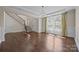 Open-concept living room featuring hardwood floors, wainscoting, and a large window at 8614 Goodman Park Ct, Charlotte, NC 28277