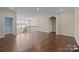 Spacious living room with hardwood floors, archway, iron staircase, and ample natural light, perfect for gatherings at 8614 Goodman Park Ct, Charlotte, NC 28277