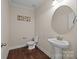 Cozy powder room featuring a pedestal sink, toilet, and decorative artwork, exuding simple elegance at 8614 Goodman Park Ct, Charlotte, NC 28277