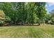 Lush backyard area with mature trees, offering ample shade and privacy at 907 Lingfield Ln, Waxhaw, NC 28173