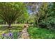 Backyard view with trees and a gravel pathway and a grass area at 907 Lingfield Ln, Waxhaw, NC 28173