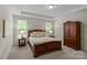 Cozy bedroom showcasing a wooden bed frame, matching furniture, and serene natural lighting at 907 Lingfield Ln, Waxhaw, NC 28173